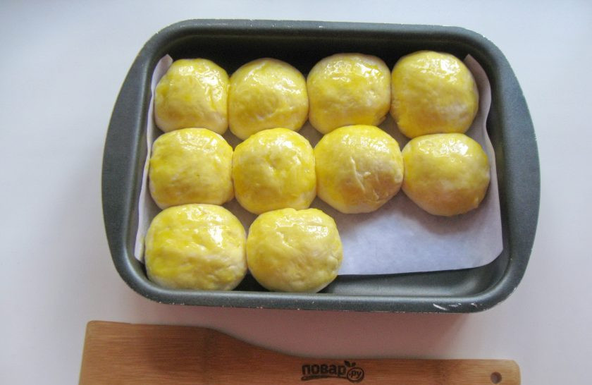 1. Этап. Пирожки с конфетами: Смажьте пирожки желтком яйца.