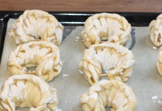 1. Этап. Плетеные булочки на молоке с начинкой: 19. Противень застилаем пекарской бумагой и раскладываем заготовки. Смазываем их жидкой сметаной или молоком. Ставим противень в теплое место, минут на 30 или до увеличения булочек в 2 раза.