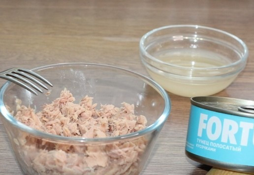 1. Этап. Слоеный салат с авокадо, тунцом, черри: 2. Выкладываем тунец без жидкости в миску. Если тунец кусочками, то разминаем его вилкой.