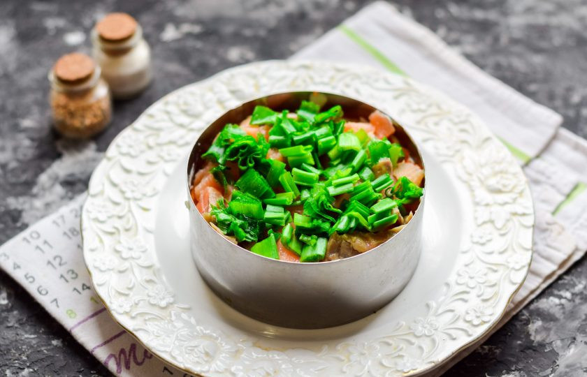 1. Этап. Салат Мимоза с красной рыбой: Зеленый лук мелко нарежьте и выложите поверх семги.