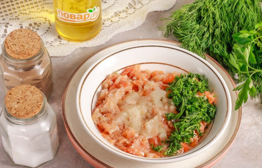 1. Этап. Пельмени с рыбой По-сахалински: В это время в рыбный фарш натрите очищенный и промытый репчатый лук на терке с мелкими ячейками. Добавьте соль и молотый черный перец. Измельчите зелень укропа и всыпьте в фарш. Все аккуратно перемешайте.