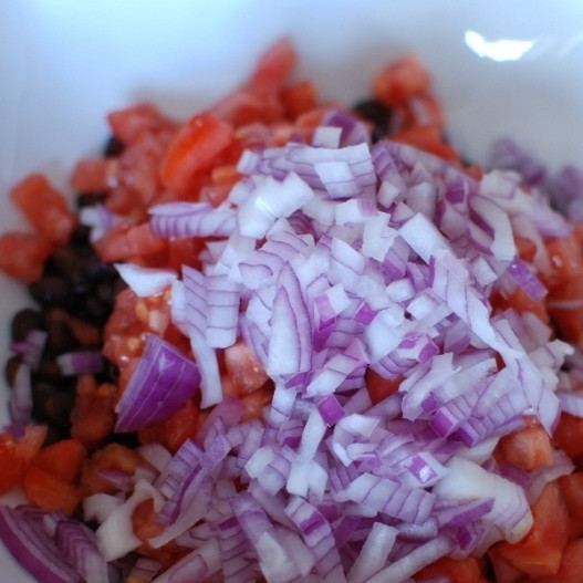1. Этап. Салат с черной фасолью: Красную луковицу мелко нарезаем и добавляем к помидорам и фасоли.