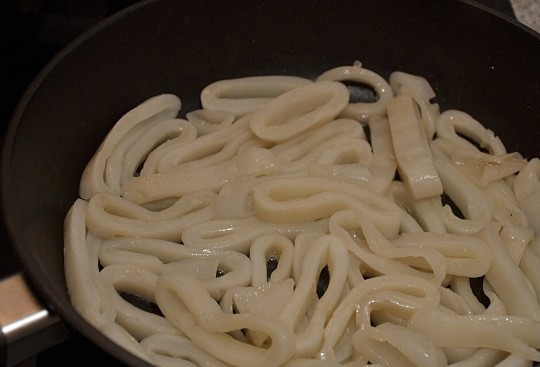 1. Этап. Макароны с кальмарами: 6. Когда чеснок начнет золотиться, аккуратно достать его. В горячее масло отправить кальмары. Обжаривать их нужно не более 4-5 минут, чтобы они не стали тугими.