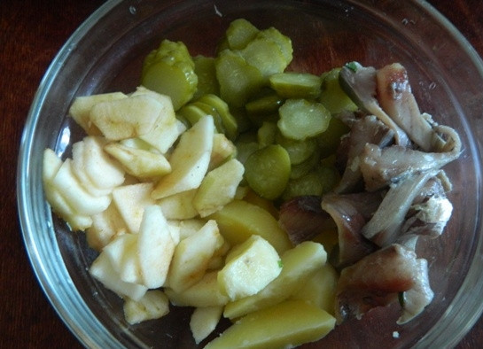 1. Этап. Салат с сельдью по-цёблицки: 5. Остывшую картошку процеживаем и выкладываем в салатник. Туда же добавляем огурцы, яблоко и филе селедки, нарезанное тонкими ломтиками.