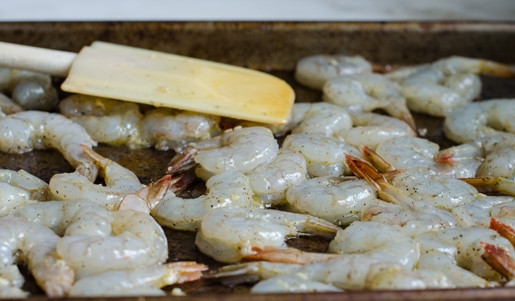 1. Этап. Креветки в масле: 1. Очищенные креветки разложите на противень. Добавьте к ним соль, перец, оливковое масло и измельчённый чеснок.