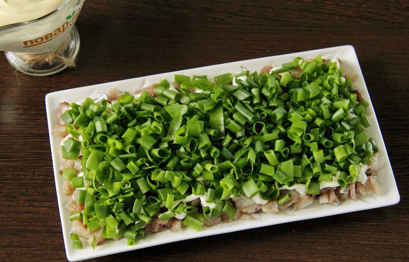 1. Этап. Салат Зеленая шуба: Второй слой - нарезанный зеленый лук. Лук слегка смазываем майонезом.