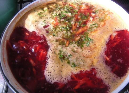 1. Этап. Борщ из свинины: 6. В бульон положить подготовленный картофель. Когда картофель проварится минут 10, добавить пассировку. Сюда же выложить нарезанную капусту, кусочки мяса, морковь и зелень петрушки. Выключить огонь и дать борщу настояться.