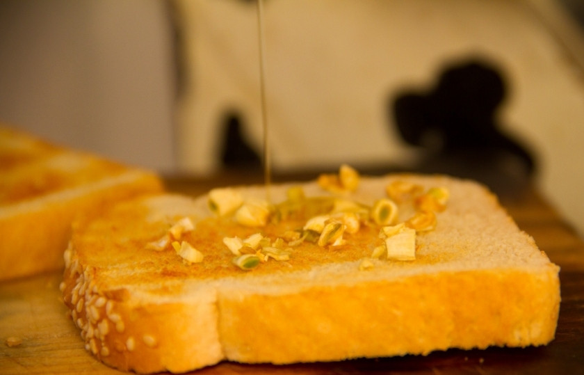 1. Этап. Бутерброды с моцареллой: Ломтики хлеба лучше обжарить, в тостере или на сковороде. Зубчик чеснока почистите и порубите мелко. Выложите на хлеб и полейте бальзамическим уксусом.