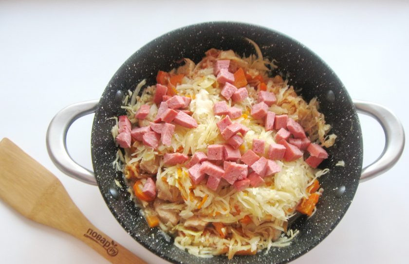 1. Этап. Солянка по-польски: После добавьте квашеную капусту в сковороду со свининой, морковью, луком и тушеной свежей капустой. Колбасу нарежьте кубиками и выложите туда же.