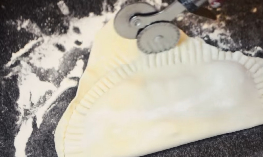 1. Этап. Домашние чебуреки: 3. Когда тесто отдохнуло, раскатайте его в продолговатую колбаску и нарежьте ее на небольшие одинаковые кусочки. По очереди раскатайте их в очень тонкий овал, положите начинку на одну половину и заверните, прижав края вилкой и обрезав все лишнее.