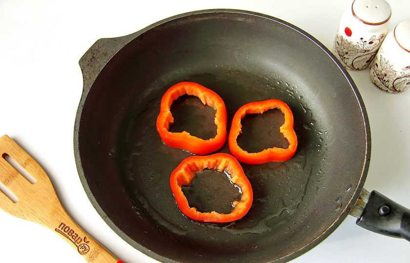 1. Этап. Яичница в болгарском перце: Сковороду разогрейте, смажьте маслом и выложите на нее колечки перца.