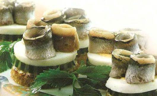 1. Этап. Канапе с килькой: 4. А теперь нанизываем на каждый кусочек хлеба с маслом кружочек яйца, огурец, и красиво выкладываем сверху кильку. Готово!