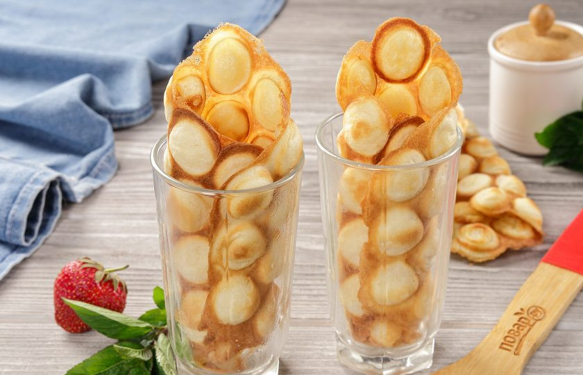 1. Этап. Гонконгские вафли: Отрежьте ножом излишки, если необходимо, и не дожидаясь остывания сразу вафлю сверните в виде рожка. Уложите свёрнутую вафлю в стакан или в другую глубокую и узкую ёмкость. Наполнители выбирайте по своему усмотрению. Для сладкого варианта используйте любой любимый крем, взбитые сливки или мороженое. Украсить вафли можно свежими ягодами или фруктами, а так же любым кондитерским декором.