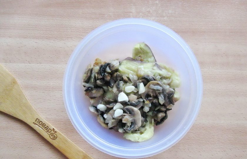 1. Этап. Паштет из баклажанов с грибами: Добавьте нарезанный чеснок. Посолите и поперчите по вкусу.