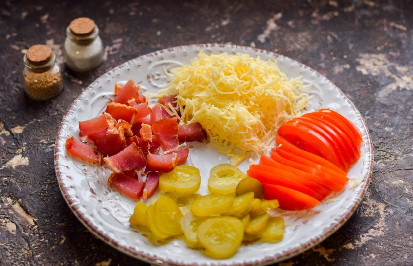 1. Этап. Пицца с грибами на сковороде: Подготовьте ингредиенты для начинки. Натрите сыр, нарежьте мясо, огурцы и помидоры.