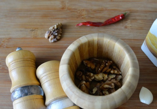 1. Этап. Салат Глехурад с индейкой: Готовим чесночно-ореховую заправку. Подсушиваем грецкие орехи пару минут на сухой сковороде, часто помешивая, чтобы они подсушились и раскрыли свой вкус. Затем пересыпаем их в ступку, добавляем чеснок, хмели-сунели, чёрный перец, хлопья перца чили и соль. Перетираем, чтобы образовалась кашица и орехи выделили масло.