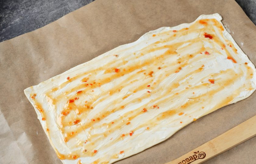 1. Этап. Канапе «Ёлочка» из слоеного теста: Слой сыра смажьте кисло-сладким соусом, желательно острым.