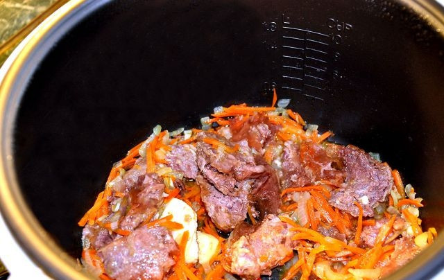 1. Этап. Гречка с тушенкой в мультиварке: Затем добавляем чеснок и тушенку.