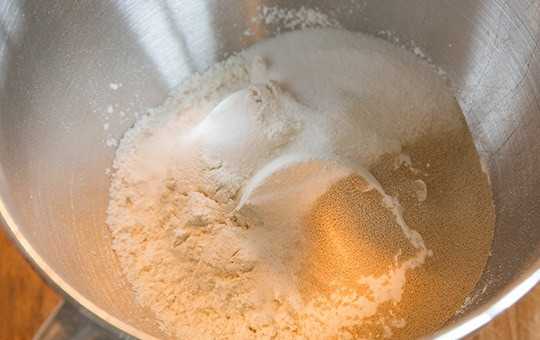 1. Этап. Булочки, как пух: 1. В миску выложите 4 стакана муки, сахар, дрожжи и соль. Перемешайте все с помощью кухонного комбайна.