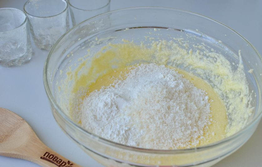 1. Этап. Кокосовые пирожные со сгущенкой: 4. Введите просеянную муку, крахмал, разрыхлитель и кокосовую стружку. Миксером доведите тесто до гладкого и однородного состояния. Можно добавить каплю ванильного экстракта или ванильный сахар.