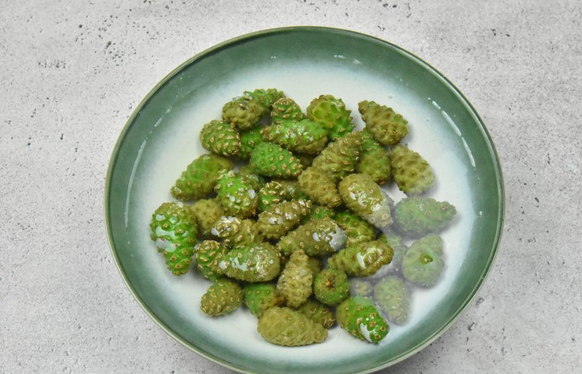 1. Этап. Сосновое варенье: Срежьте ножницами грубые веточки крепления, удалите лишний мусор. Выложите шишки в миску и залейте холодной водой. Оставьте на сутки.