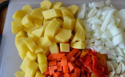 1. Этап. Тыква, фаршированная овощным рагу с индейкой: Берём лук, картофель, перец, морковь, чеснок. Всё моем, чистим. У меня - замороженный болгарский перец, красный и жёлтый. Картофель режем крупными кубиками, морковь, перец и лук, мелкими кубиками. Также мелко режем чеснок.