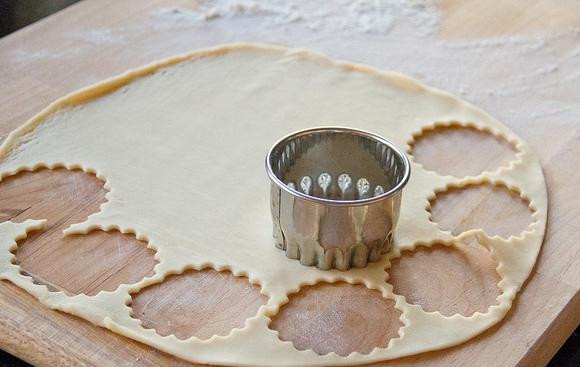 1. Этап. Мини-пирожки на палочке: 1. Разогреть духовку до 190 градусов. Выстелить 3 противня пергаментной бумагой или силиконовыми ковриками. Выложить тесто на рабочую поверхность и с помощью рифленой формочки (или обычной круглой) вырезать кружки диаметром 6 см.