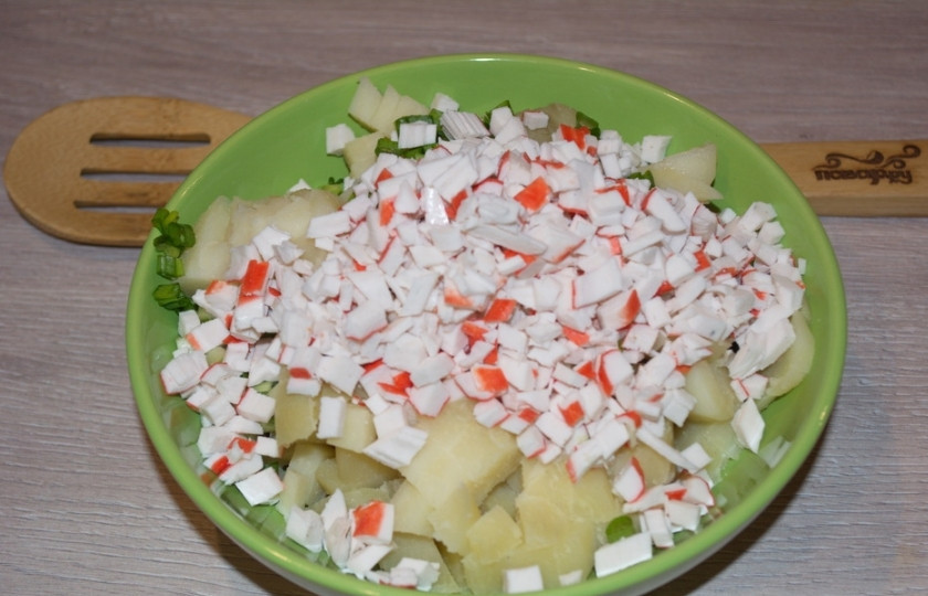 1. Этап. Салат Уральские самоцветы: Крабовые палочки нарезаем небольшими кубиками. Добавляем нарезанные палочки в салатник к остальным продуктам.