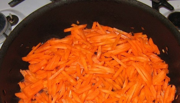 1. Этап. Печеночный торт классический: Морковочку поскоблите ножом и хорошенько вымойте под проточной водой. Натрите ее на крупной терке. В сковородку влейте растительное масло без запаха, разогрейте его на плите, выложите в сковородку морковку.