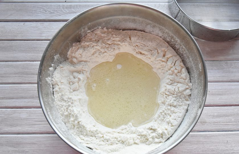 1. Этап. Момо с курицей: В воде растворите соль. Влейте масло и столовый уксус, размешайте. Получившуюся эмульсию влейте в углубление в муке.