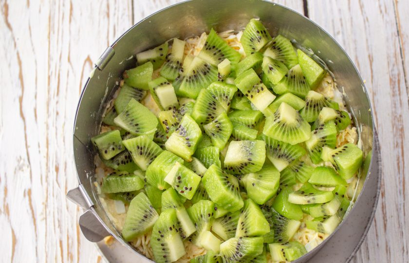 1. Этап. Салат Нежность с курицей, грецким орехом и киви: Салат выложите слоями, промазывая майонезом в таком порядке: курица, орехи, сыр, яйца, киви. Уберите в холодильник для стабилизации на 1-2 часа.