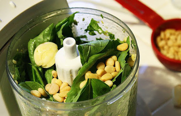 1. Этап. Курица с соусом песто: 1. Безусловно, купить соус песто можно и в магазине, однако лучше сделать его самостоятельно. Тем более, что ничего сложного в приготовлении нет. В чашу блендера или ступки отправить вымытый и просушенный базилик, очищенный чеснок, кедровые орехи. Пармезан натереть на терке и добавить в блендер. Взбить немного, чтобы получилась однородная консистенция.