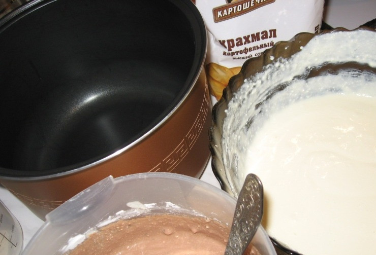 1. Этап. Творожный десерт в мультиварке: Сливки наливаем в кастрюльку и ставим на огонь, нагреваем, но не даем закипеть, растапливаем в сливках шоколад. В отдельной посуде смешиваем творог, яйца и сахар, взбиваем блендером. Теперь разделяем творожную смесь на две части и в одну добавляем сливки с шоколадом, перемешиваем. Затем добавляем в обе части по две ложки крахмала и еще раз перемешиваем.