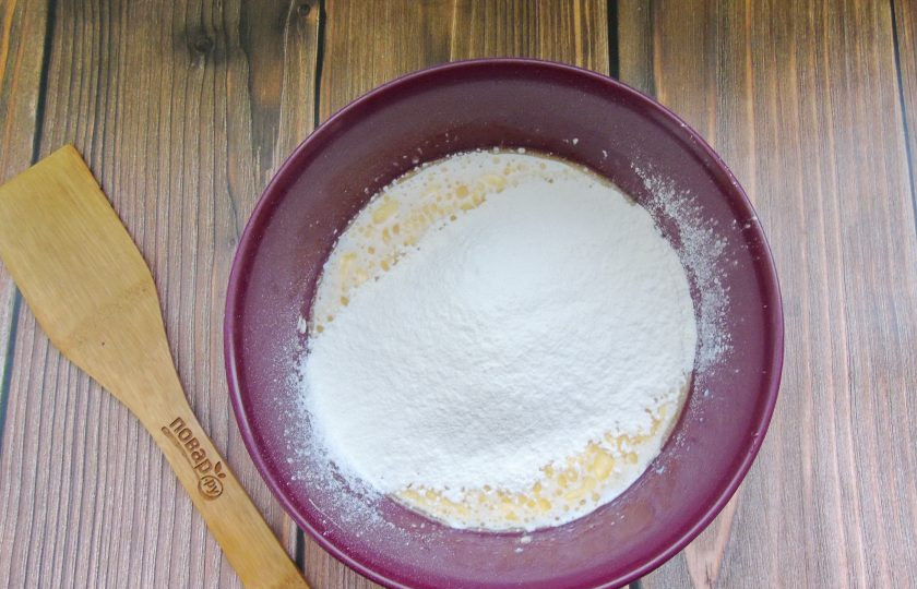 1. Этап. Пирожки с яблоками и вишней: Постепенно насыпьте просеянную муку.