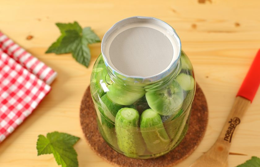 1. Этап. Огурцы с зелеными помидорами на зиму: В кастрюльке доведите до кипения необходимое количество воды и после того, как вода закипит, залейте ею банку с огурцами и помидорами. Прикройте банку крышкой и дайте постоять 10 минут.