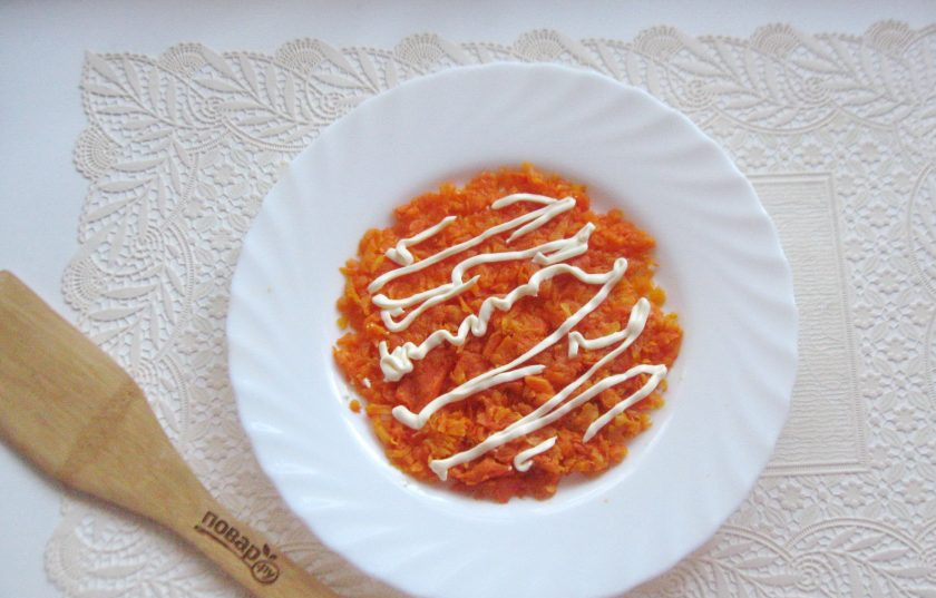 1. Этап. Салат с консервированной горбушей и грибами: Морковь сварите, охладите и очистите. Натрите на терке и выложите первым слоем салата. Нанесите майонез на морковь.