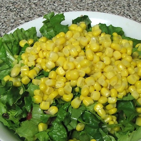 1. Этап. Салат из тунца консервированного: Добавляем в салат листья салата и кукурузу.