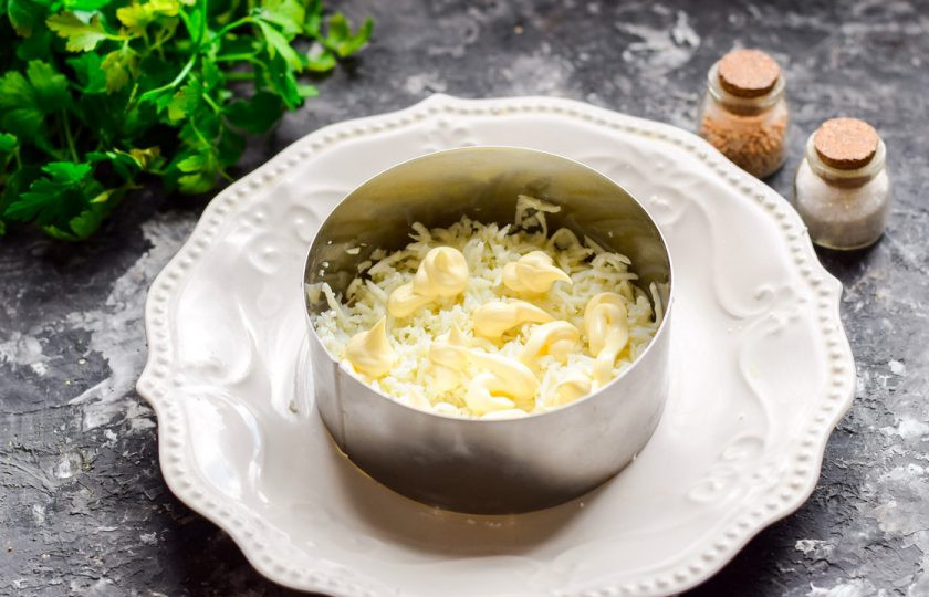 1. Этап. Салат Мимоза с кальмарами: Куриные яйца отварите вкрутую, почистите и отделите белки от желтков. Белки натрите на мелкой терке и смажьте майонезом, выложите первым слоем.