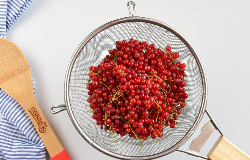 1. Этап. Компот из красной смородины на зиму: Смородину залейте холодной водой, промойте, мусор и листочки всплывут наверх, слейте. Откиньте на сито и еще раз ополосните смородину. Переберите, чтобы не попались порченые ягодки.