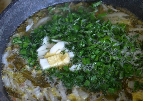 1. Этап. Зелёный борщ Походный: Кладём в борщ рубленую зелень и порезанное вареное яйцо. Перемешиваем, пробуем на соль и кислоту. Мне всегда не хватает кислоты, добавляю рассол от маринованных огурцов.