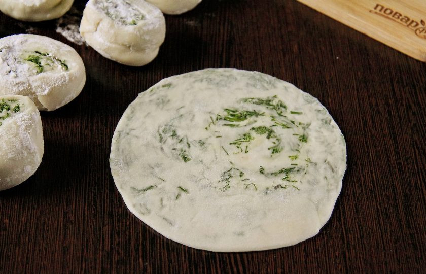 1. Этап. Лепешки с укропом: Прижмите каждый кусочек теста сверху рукой, обваляйте с двух сторон в муке и раскатайте в форме круга. Толщина лепешек может варьироваться на ваше усмотрение от 3 до 5 мм.