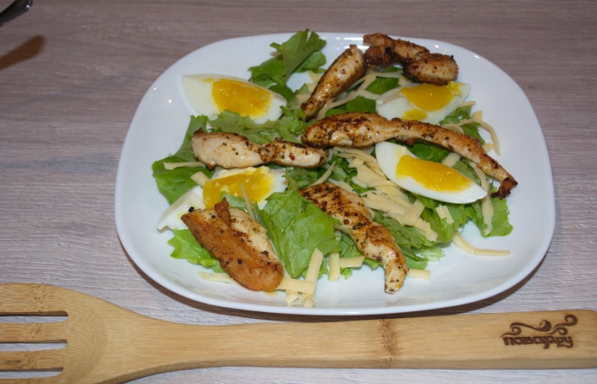 1. Этап. Салат А-ля Цезарь: Отварите куриные яйца. На растительном масле обжарьте куриное филе (перед обжариванием филе следует посолить). Яйцаочистите и нарежьте на кусочки. Куриному филе дайте остыть. На салатные листья выложите подготовленные продукты.