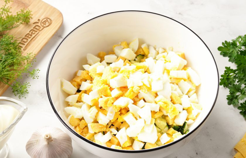 1. Этап. Салат с яйцом, сыром, кукурузой и огурцом: Яйца очистите и нарежьте примерно такими же кубиками.