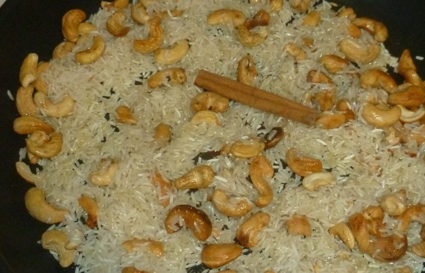 1. Этап. Пилаф с кешью: Выложите рис, палочку корицы и залейте все горячим бульоном. Посолите, доведите до кипения.