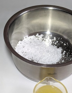 1. Этап. Лимонно-мандариновый миндальный пирог: Для сиропа сахарную пудру всыпать в небольшой сотейник, поставить на небольшой огонь до растворения сахара. Сахар не должен жариться, а только раствориться. У меня получилось 60 мл сока, я взяла весь, пирог с лимонной кислинкой. Если вы не любитель кислого, возьмите 30 мл сока и 30 мл воды.