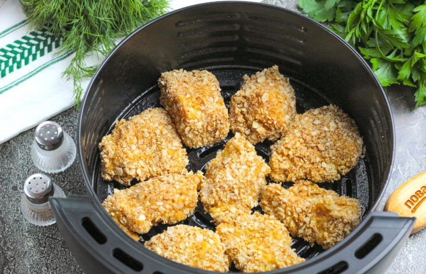 1. Этап. Наггетсы в аэрогриле: Сбрызните растительным маслом поддон аэрогриля и выложите заготовки в него, стараясь оставлять между ними немного пространства, чтобы проходил воздух.