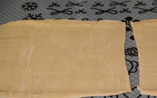 1. Этап. Яблочный штрудель простой: Слоеное тесто достаньте из морозилки и дайте ему оттаять при комнатной температуре. Раскатайте тесто в тонкий пласт. Растопите сливочное масло и смажьте им поверхность теста.