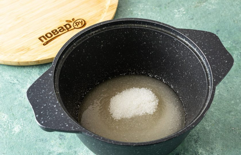 1. Этап. Повидло из тыквы с апельсином: В кастрюле с толстым дном вскипятите воду с сахаром. Доведите до кипения и проварите, пока сахар полностью не растворится.