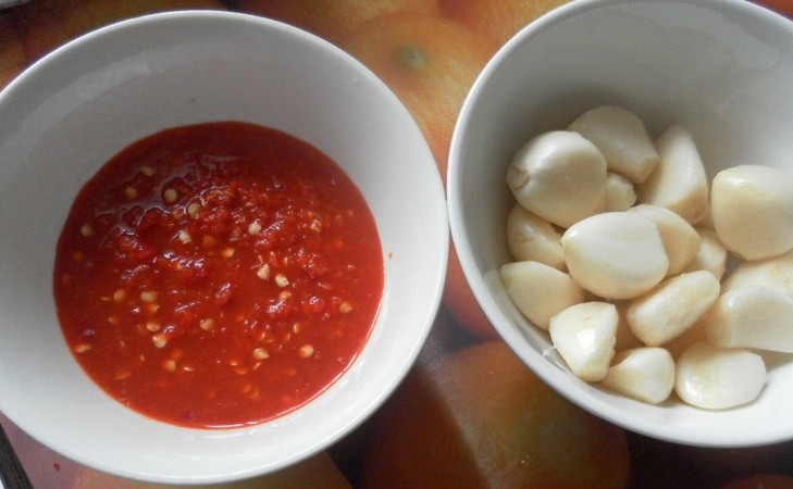 1. Этап. Аджика простая: Перекручиваем порезанные томаты, перец и чеснок через мясорубку. Вливаем растительное и оливковое масло, уксус, солим по вкусу. Тщательно все перемешиваем.