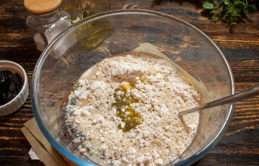 1. Этап. Хлеб с черносливом: Влейте подошедшую опару и оливковое масло.